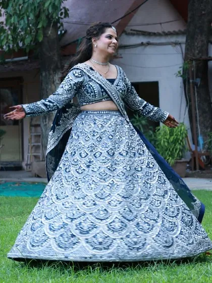 Create a striking reception or sangeet look with this heavily embroidered navy blue lehenga. The intricate silver work photographs beautifully and adds a touch of glamour to any makeup artist's portfolio.