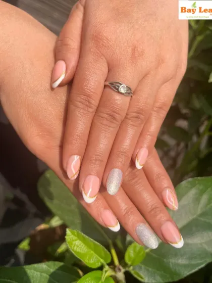 A beautiful French manicure captured in the sunlight. This design features a clean, natural look with white tips and a single silver glitter accent nail for a touch of sparkle.