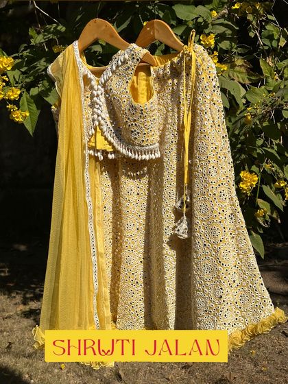 A closer look at my yellow mirror-work lehenga set. The crop top is adorned with pearl tassels, and the skirt is lightweight and perfect for twirling, making it a favorite for sangeet nights.