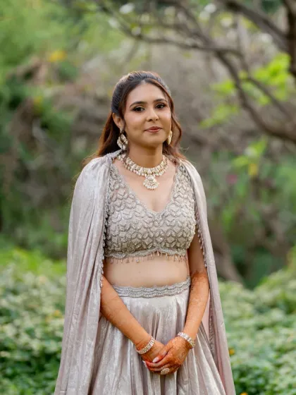 A beautiful outdoor portrait of Darshali. Her makeup is natural and timeless, ensuring she looks effortlessly beautiful in her stunning silver reception outfit.