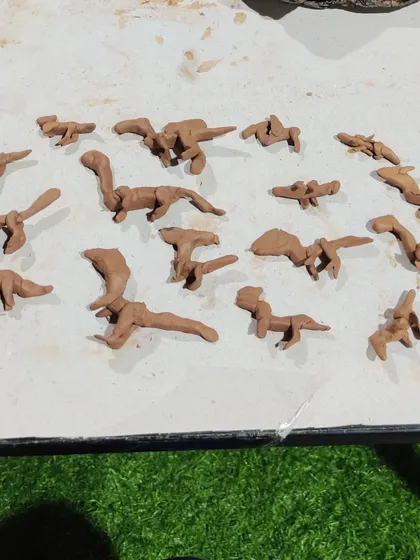 A whole herd of clay dinosaurs ready for adventure. In my kids' workshops, we encourage them to explore their interests and tell their own stories through sculpture.