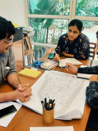 A typical design discussion at my studio. Here, my team and I are reviewing architectural blueprints, a crucial part of my hands-on, collaborative process that ensures every detail is considered from concept to execution.