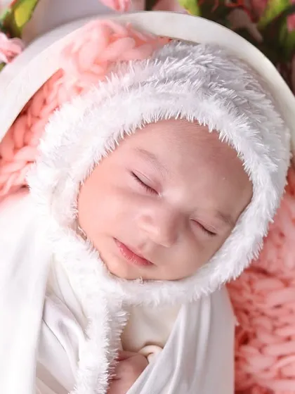 An intimate portrait focusing on the baby's delicate features and the soft, fluffy texture of the bunny-ear bonnet.