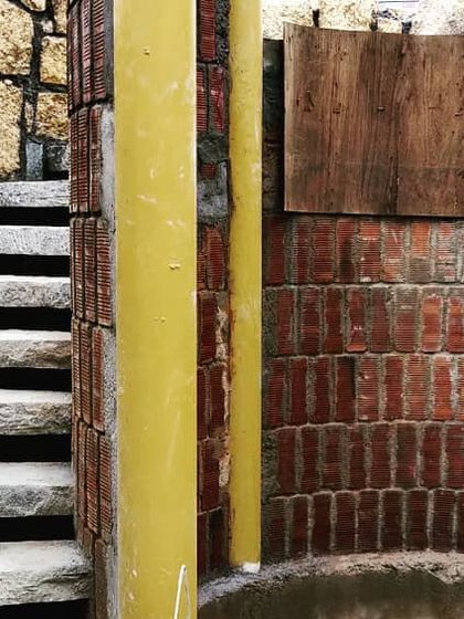 This circular staircase combines rough-hewn stone steps with a curved brick wall, creating a rustic and tactile experience. The design shows our love for raw, earthy materials in creating unique structural elements like this lift well.