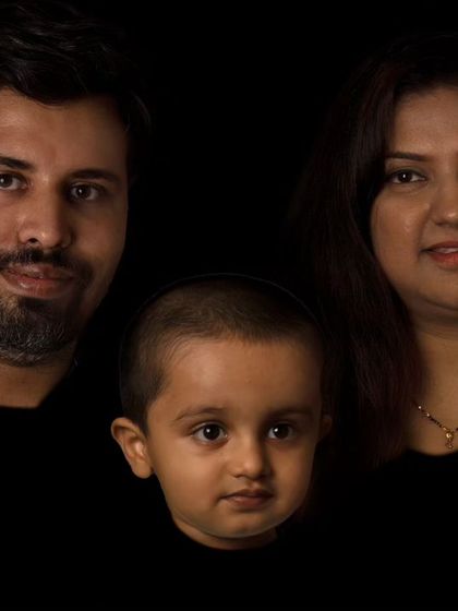 An artistic, low-key family portrait. This creative style uses shadows to sculpt the faces, resulting in a dramatic and memorable image.