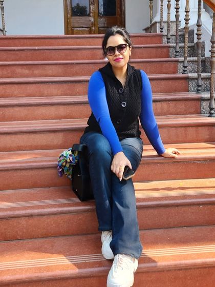 A casual winter look with jeans, a bright blue sweater, and a black vest. Layering is key for both warmth and style.