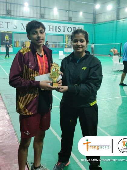 A coach presenting a trophy to a tournament winner.