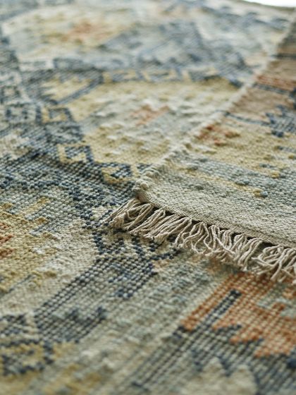 The corner of one of our dhurries, highlighting the fringe and the texture of the weave. This is where you can see the magic of handwoven craftsmanship and the care that goes into each piece.