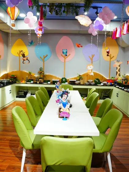 Our cafe area is seamlessly integrated into the party space, allowing guests to dine in a beautifully decorated environment. Here, the tables are set for a royal feast.