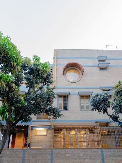 The side facade of Audumbara, showing the circular window and bamboo fencing.