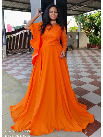 Stand out at any party or event with this vibrant orange long frock. The delicate lace work on the bodice and the flowing georgette skirt make it a comfortable yet eye-catching choice for any celebration.