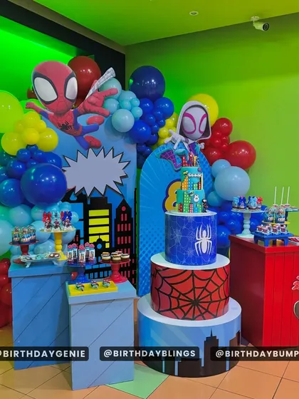 A multi-level Spider-Verse party setup, complete with Spider-Man, Ghost-Spider, and Miles Morales. The cityscape backdrop and themed dessert tables create a full superhero universe for guests to enjoy.