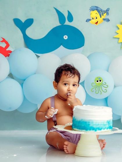 An 'Under the Sea' cake smash is always a splash. This little one is enjoying his ocean-blue cake surrounded by cute sea creatures.