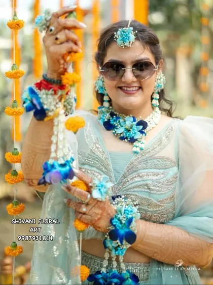 Your Haldi jewellery doesn't have to be yellow. I love creating unique looks, like this stunning set made with fresh blue orchids and Tagar buds. It’s a modern twist that adds a cool, refreshing touch to the celebration.