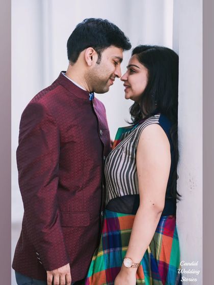 A close-up, intimate portrait of a couple, using the simple background of a pillar to draw all the focus to their gentle interaction.
