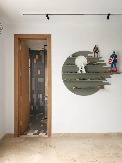 A unique circular shelf in the kid's room provides a creative way to display toys and collectibles. This custom piece adds a touch of modern design to the playful space.