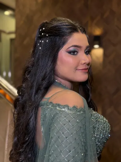 A side profile highlighting the intricate hairstyle with pearl embellishments and the beautifully blended smokey eye makeup. This is a complete party-ready look.