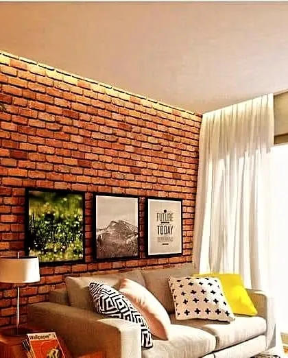 This cozy living room corner is made warmer and more inviting with a classic red brick accent wall, showing how it can complement both modern and traditional decor.