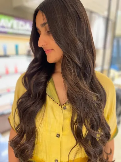 The client looking radiant with her new peek-a-boo highlights. The subtle color and soft waves create a beautiful, natural-looking style.