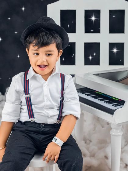 A little musician in the making! This stylish boy looks right at home with his tiny piano against a starry night sky.