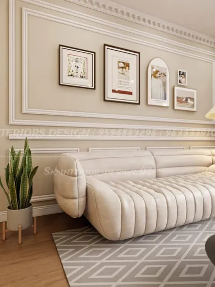 A close-up on a plush, modern sofa set against a wall with decorative molding. This image highlights how we use wall treatments and curated art to create a gallery-like feel.