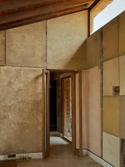 The custom-colored 'kada' plaster walls are a key feature of the Kamshet farmhouse interior. We developed these unique pigments with our artisans on-site, creating a palette of earthy tones that add warmth and depth to the rooms.