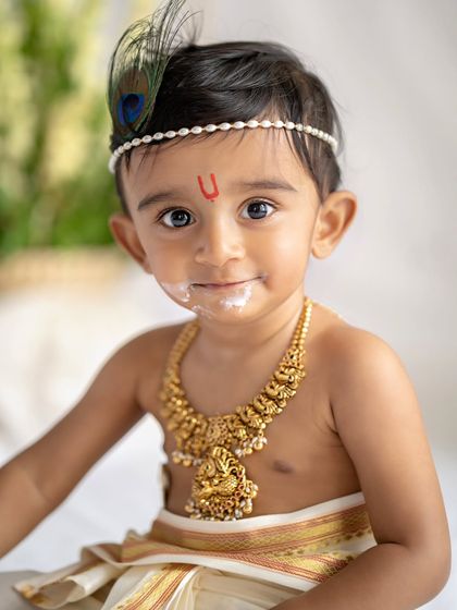 A close-up of our little Krishna with a touch of butter on his lips. This shot perfectly captures the playful and mischievous nature that is so central to the Krishna theme.