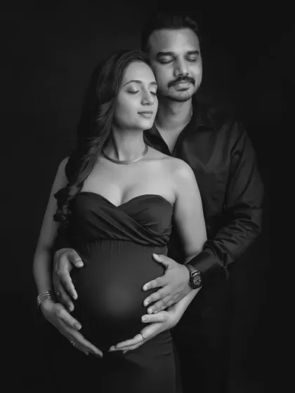 A powerful and serene black and white portrait. With both your hands on the bump, this image symbolizes your shared journey and the love that surrounds your growing baby.