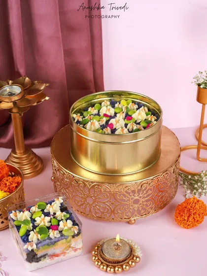 A creative sushi cake decorated with edible flowers, presented in a tin for Diwali. This shot showcases a unique fusion of Japanese cuisine and Indian festivity.