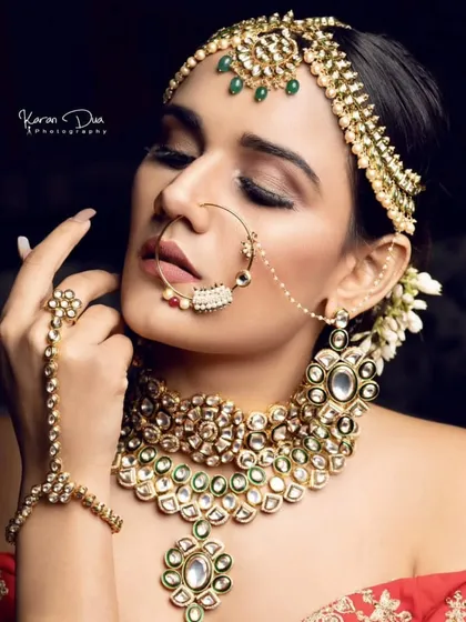 A professional shot of a model wearing a Pachi Kundan set with a delicate nath and hathphool. This highlights the fine craftsmanship of my pieces.