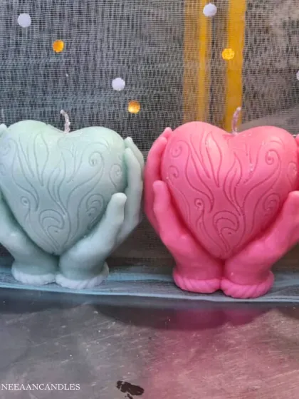 Holding a little light, a little love. These candles, shaped like hands holding a heart, tell a story of warmth and care with every glow.