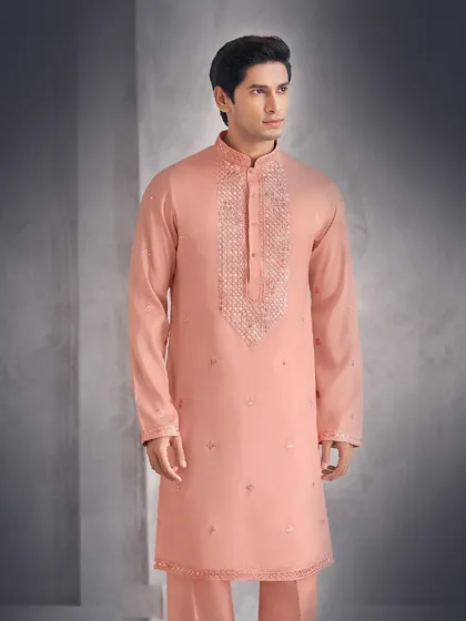 This peach-colored kurta is adorned with delicate embroidery around the placket and scattered across the body. It is a soft and sophisticated choice for daytime events.