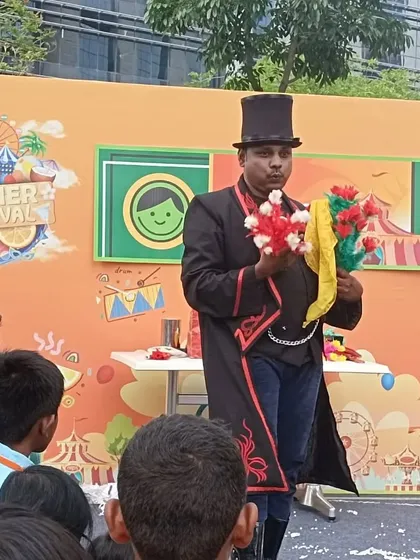 Showing off a flower trick to an eager young audience at a corporate summer carnival. My magic is colorful, visual, and easy for everyone to enjoy.