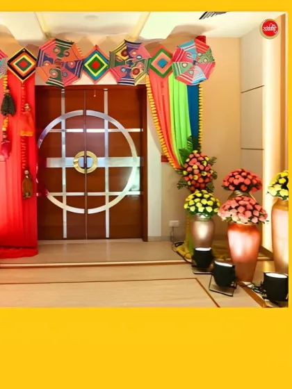 A traditional and colorful Haldi entrance, featuring vibrant drapes, decorative Rajasthani umbrellas, and pots of bright yellow and orange flowers.