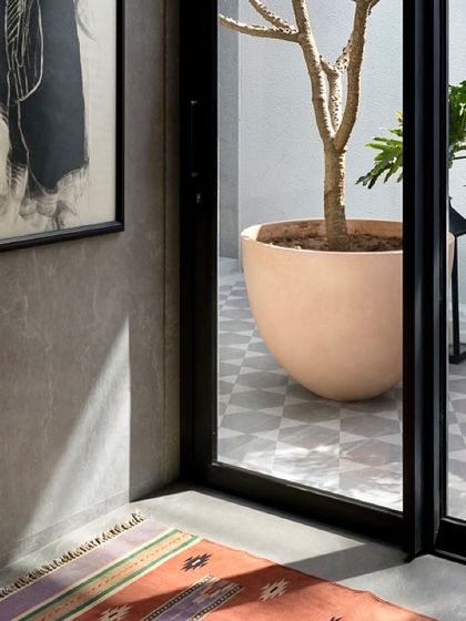 Sunlight casts beautiful shadows across the floor in this passage overlooking a courtyard in the Mango Orchard House, demonstrating our focus on natural light architecture.