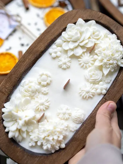 Our boat candles are the bestseller of the season. This one is beautifully decorated with an assortment of white wax flowers and has a rustic wooden wick.