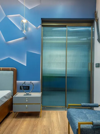 The fluted glass sliding doors of the wardrobe add another layer of texture and sophistication, complementing the room's modern aesthetic while providing a hint of what's inside.