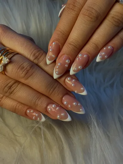 A timeless look with a touch of sophistication. We elevated the classic white French manicure by adding delicate pearl accents for a look that's perfect for a bride or any special occasion.