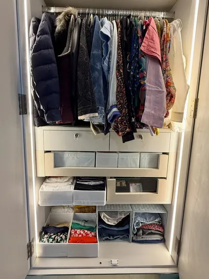 This image shows a variety of storage solutions within one closet, including hanging space, open-front bins, and pull-out drawers, all working together in harmony.