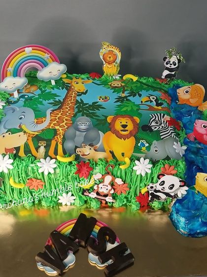 A grand jungle-themed cake with a whole host of animals, a waterfall, and a rainbow. This large sheet cake is great for bigger parties.