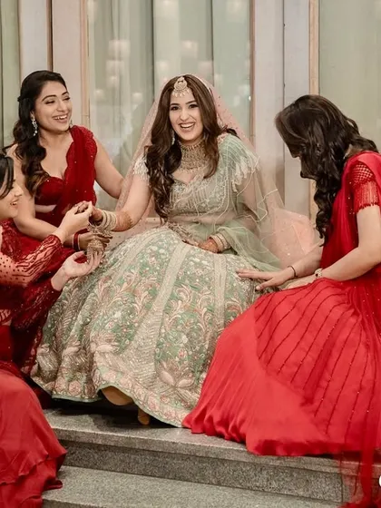 A happy bride surrounded by her bridesmaids. Her makeup is soft and natural, allowing her joy to be the centerpiece of the photograph.