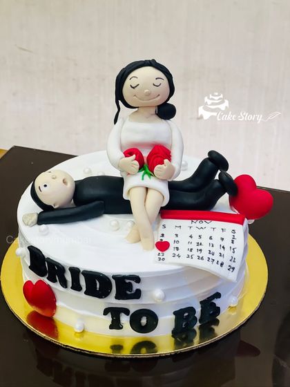A closer look at the details on the 'Bride to Be' cake, including the hand-molded fondant figures and the tiny heart on the calendar.