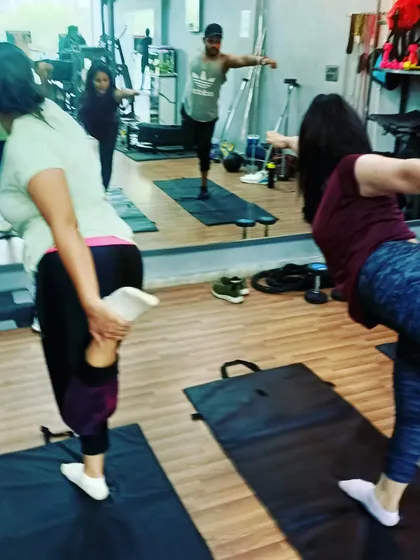 A student transitioning into a balancing pose, demonstrating the focus and dedication required in our workouts. Consistency is the key to progress.