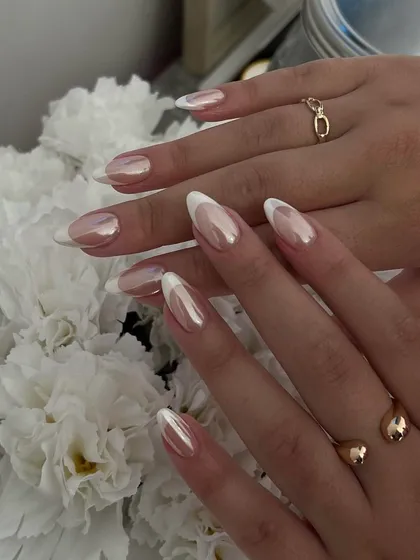 A stunning chrome French manicure. The base has a pearly chrome finish, and the tips are a classic white, creating a beautiful, iridescent look that is very popular right now.