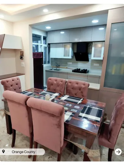 A compact dining nook adjacent to the kitchen. The plush pink chairs add a pop of color and comfort to the space.