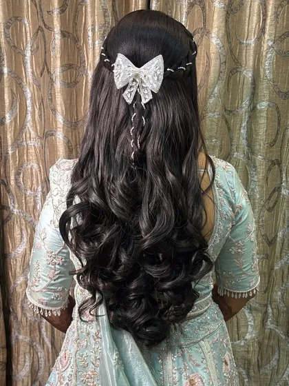 We also master modern hairstyles for receptions and parties. This elegant look with soft curls and a delicate bow is perfect for any celebration.