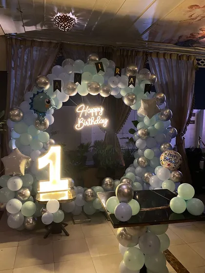A first birthday party with a pastel blue and silver color scheme and a cute dinosaur theme.
