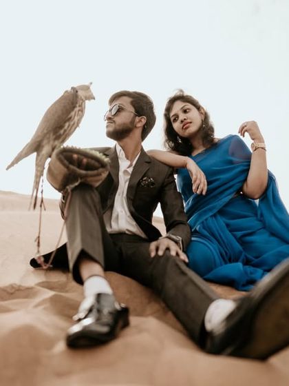 A truly unique destination experience, this pre-wedding photo incorporates a majestic falcon, adding a touch of Arabian heritage and drama to the desert shoot.