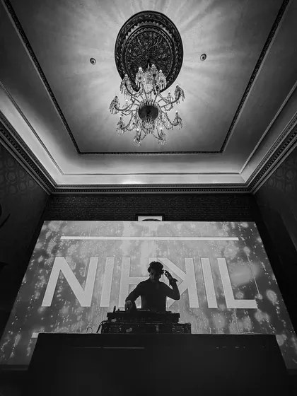 A dramatic black and white shot of me performing under an elegant chandelier. I can adapt my high-energy style to even the most sophisticated venues.