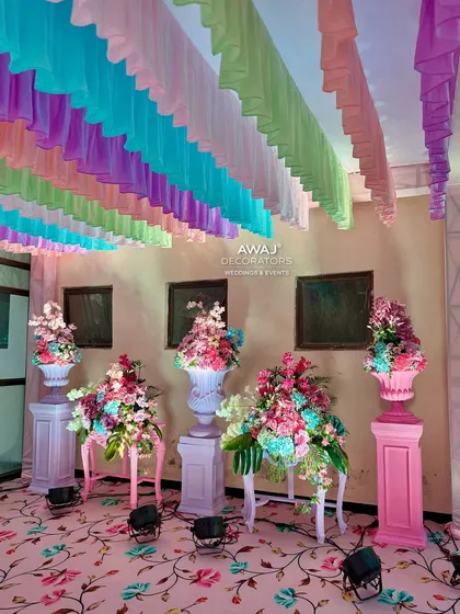 A collection of pastel-colored urns and stands with multi-colored floral arrangements, creating a grand welcome.